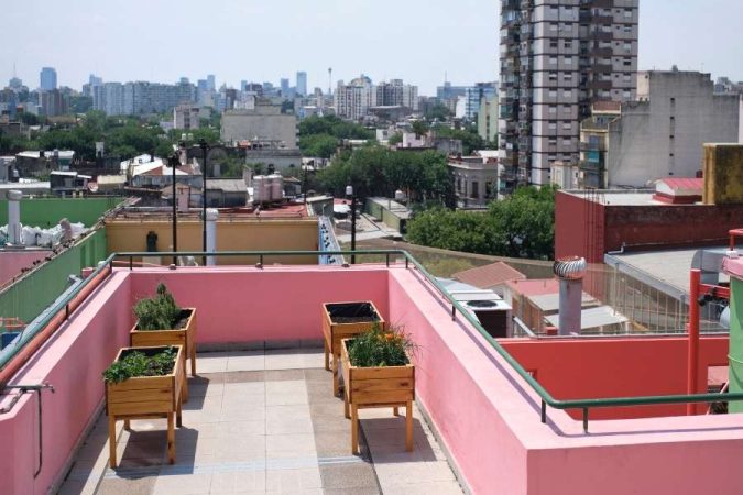 Un potager de toit avec des bacs de plantation en bois disposés sur la terrasse urbaine.