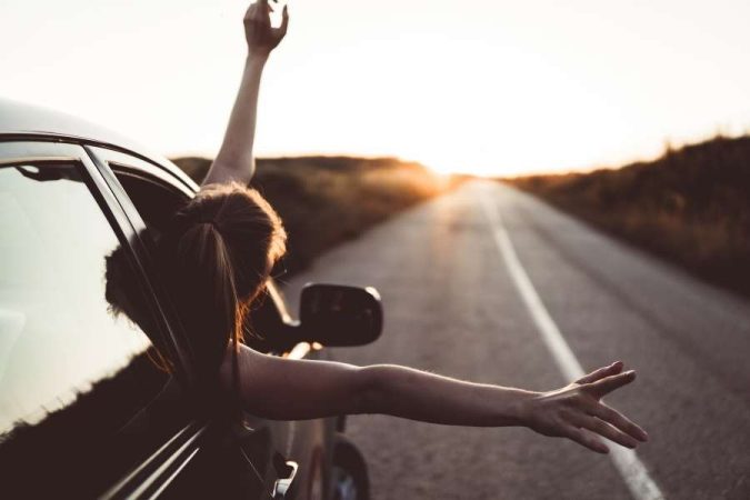 Une voyageuse profite de la route, illustrant la liberté offerte par une bonne gestion du budget quotidien.