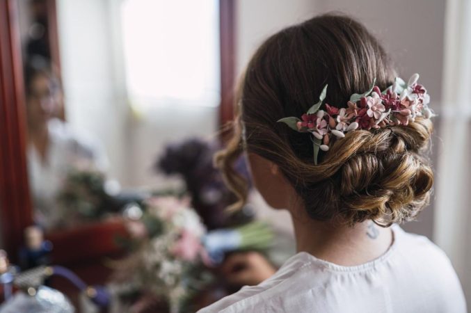 Chignon bas flou orné d'un peigne fleuri, parfait exemple d'idees coiffure mariage cheveux mi longs.